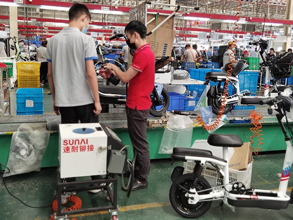 速耐技術(shù)負責(zé)人協(xié)助愛瑪員工使用自動拉釘機設(shè)備